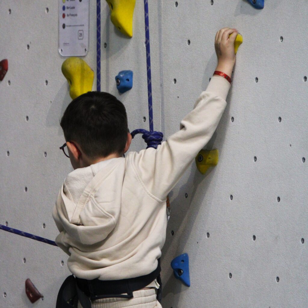 Un enfant qui fait de l'escalade sur corde.